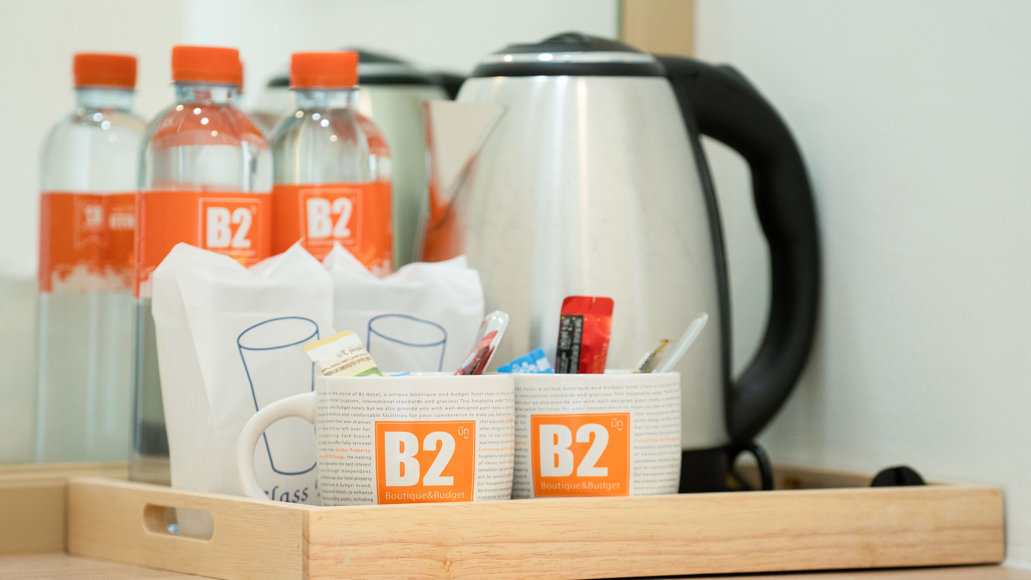 A tray with B2 branded bottles, a mug, and a kettle.