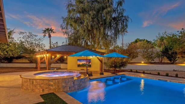 A swimming pool with a hot tub, a gazebo, and outdoor seating. - Heated Pool w/ swim up bar seating & Spa, Pool Table, Basketball Court, Putting green + FREE Golf! (Scottsdale)