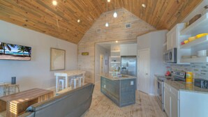 Een moderne keuken met een houten plafond, witte kasten en een centraal eiland.