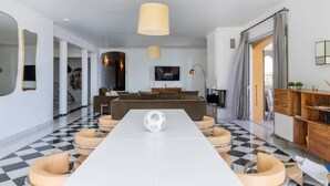 A modern living room with a large white table, a brown sofa, and a checkered floor. - VILLA DOLCE VITA- 8 bedrooms, sea view, swimming pool, (Ajaccio)