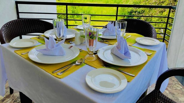 Taula preparada per a dinar amb vista a un paisatge verdós i exuberant.