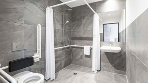 Un bagno moderno con doccia, servizi igienici e lavabo.