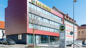 Un bed and breakfast con una facciata moderna, ampie finestre e un'area di parcheggio ben visibile.