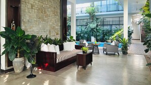 A spacious indoor area with a large seating area, a pool, and abundant greenery. - Maison Leab (Siem Reap)