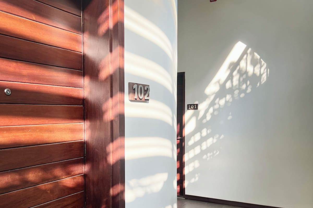 A hallway with wooden paneling and a number 102 sign.