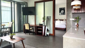 A hotel room with a bed, a desk, a TV, a dining area, and a bathroom. - Maison Leab (Siem Reap)
