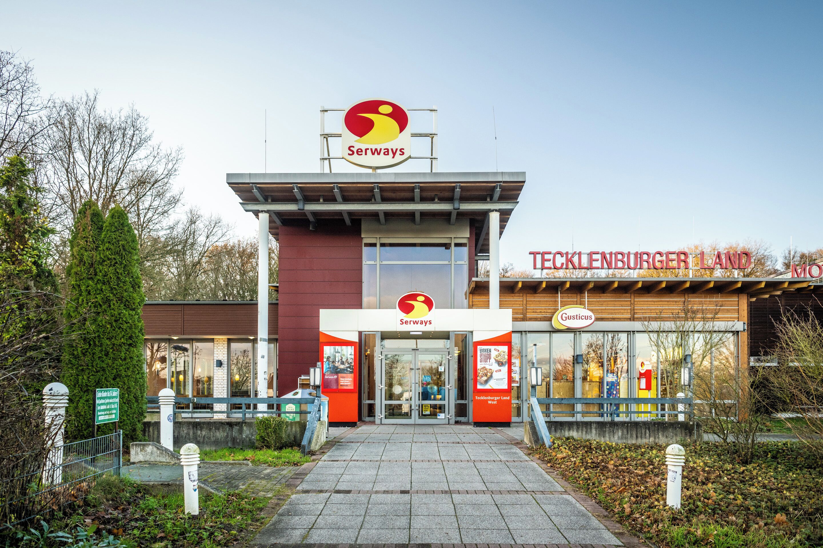 Ein Serways Restaurant mit modernem Design, das ein auffälliges Logo und ein Schild für Tecklenburger Land zeigt.