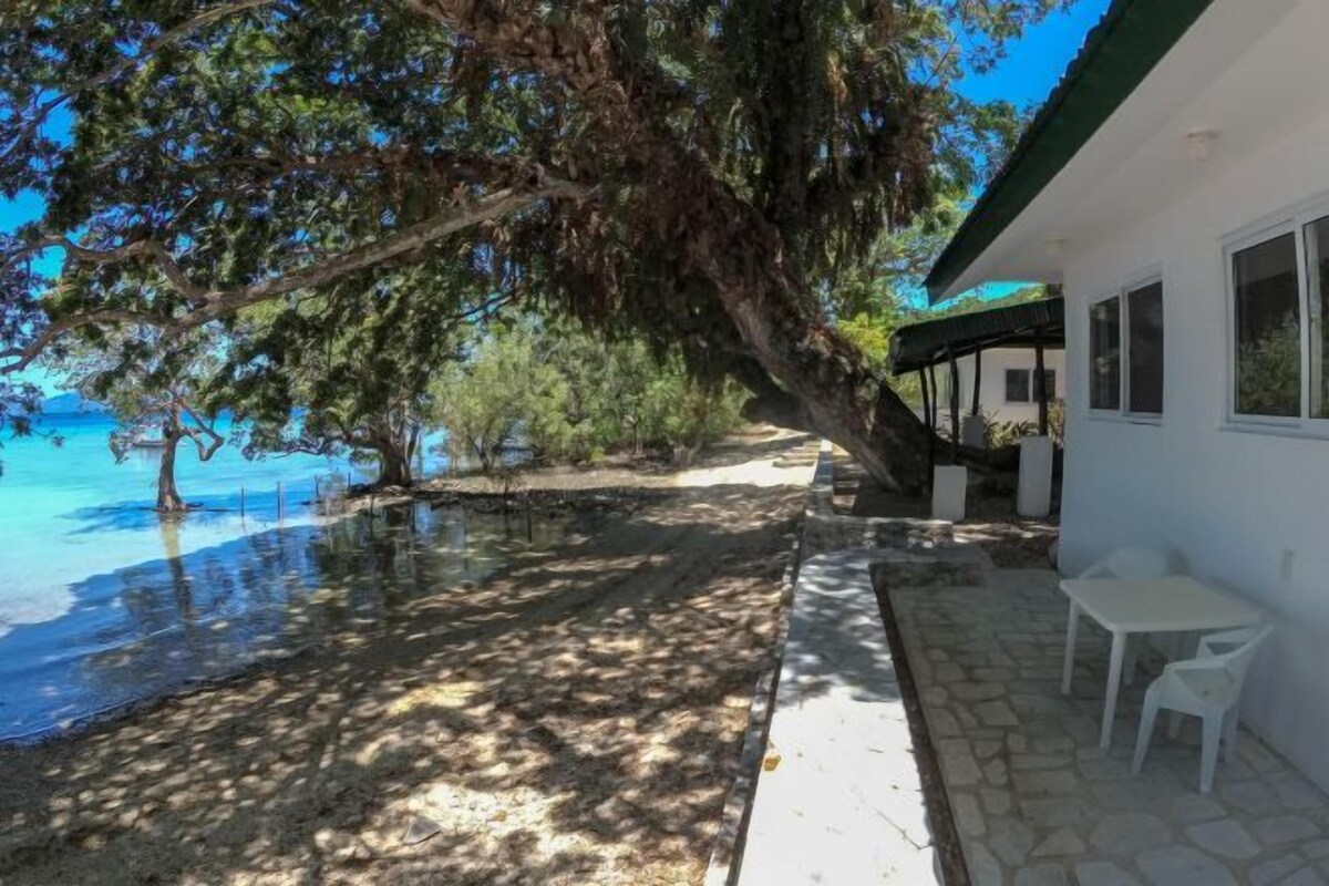A coastal property with a patio, outdoor seating, and a view of the sea.