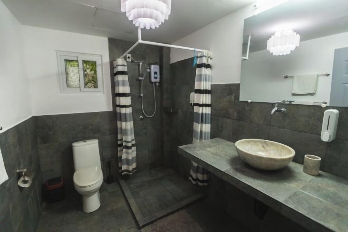 A bathroom with a shower, toilet, and sink.