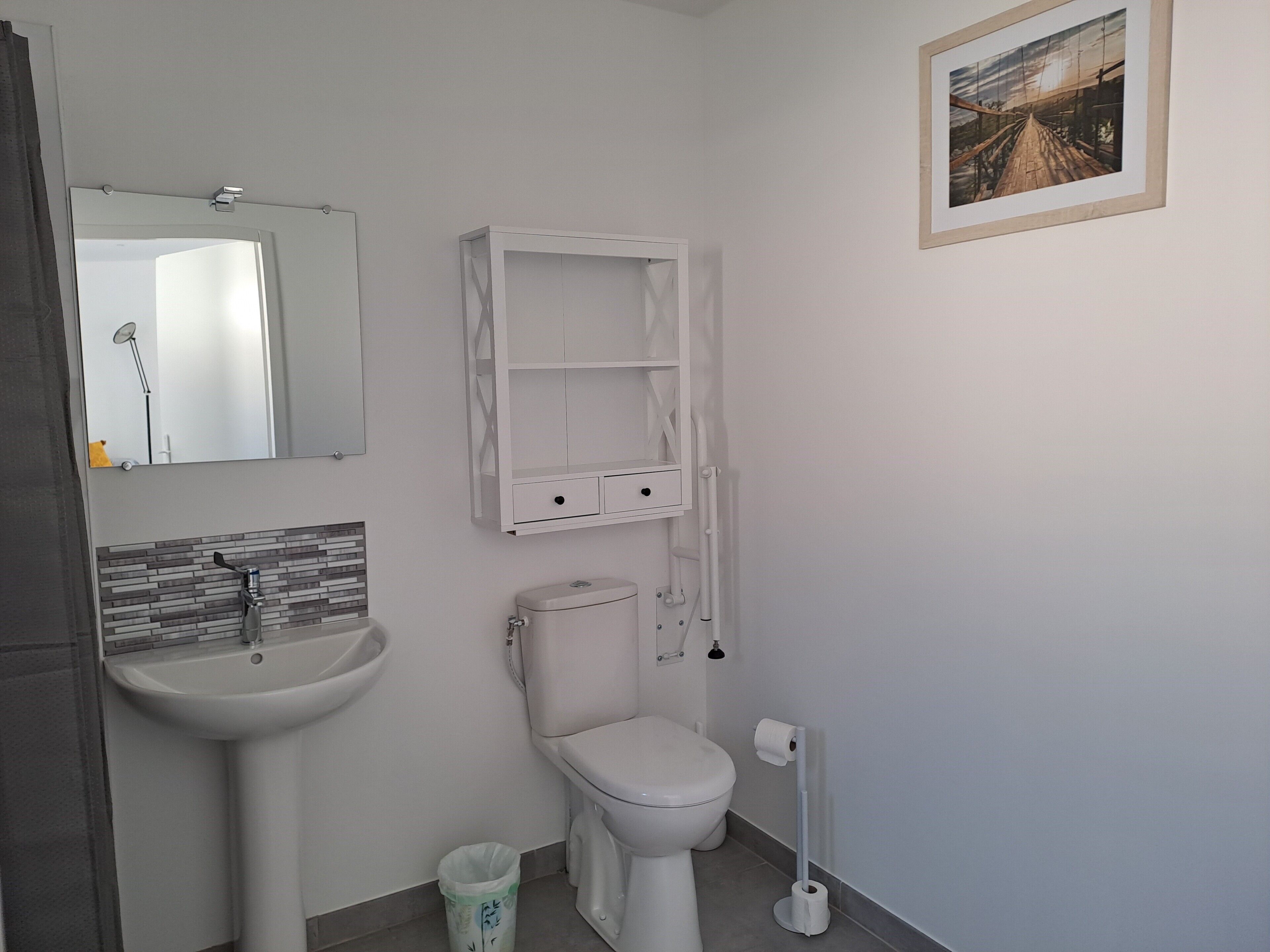 Un bany amb un lavabo, vàter i mirall.