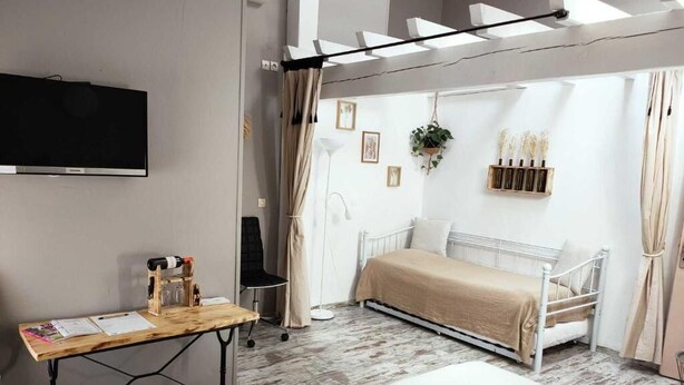 A modern bedroom with a bed, a desk, a TV, and a window with curtains. - Château Pierre de Montignac (Civrac-en-Medoc)
