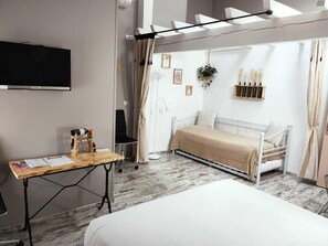 A modern bedroom with a bed, a desk, a TV, and a window with curtains. - Château Pierre de Montignac (Civrac-en-Medoc)