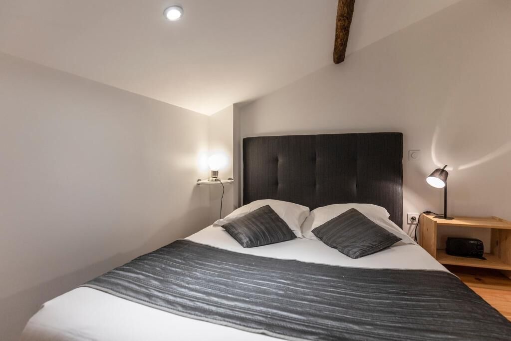 Une chambre à coucher avec un grand lit, deux tables de chevet et une petite table en bois.