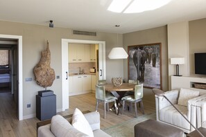 A modern living room with a dining area, a large abstract painting, and a television.