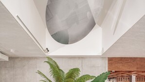 A modern interior with a large spherical ceiling feature, a green sofa, and a variety of plants. - Hôtel Vertime (Les Sables-d'Olonne)