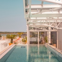 Una piscina al aire libre de temporada, tumbonas