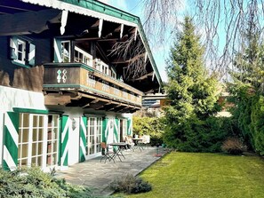 Un chalet traditionnel doté d’un balcon, d’un espace extérieur aménagé et d’un jardin bien entretenu.