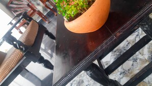 A dining table with a terracotta pot containing green plants, surrounded by wooden chairs. - Hill House Haldummulla (Haldummulla)