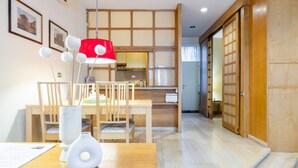 A traditional Japanese-style room with tatami flooring, a low wooden table, a white vase, and a red lamp. - Hiro Studio - Spanish Steps (Roma)