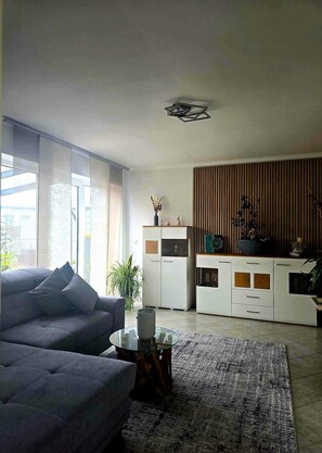 Una sala de estar moderna con un sofá, una mesa de centro y un mueble aparador.
