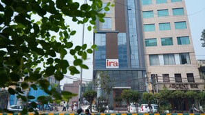 A modern building with a sign for 'Ira Hotel' and 'Ascend Biz' on the ground floor. - IRA By Orchid Noida (Noida)