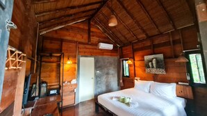 Une pièce dans une cabane en bois, comprenant un lit, un bureau et une porte.
