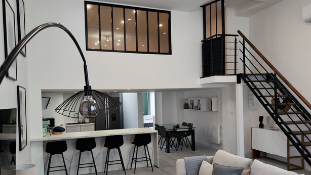 Una sala moderna con un sofá, una mesa de centro y un comedor con sillas y una mesa.