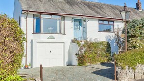 A two-story house with a white facade, a blue door, and a chimney. - Lothlorien in Grange-over-sands With Bay Views (Grange-over-Sands)