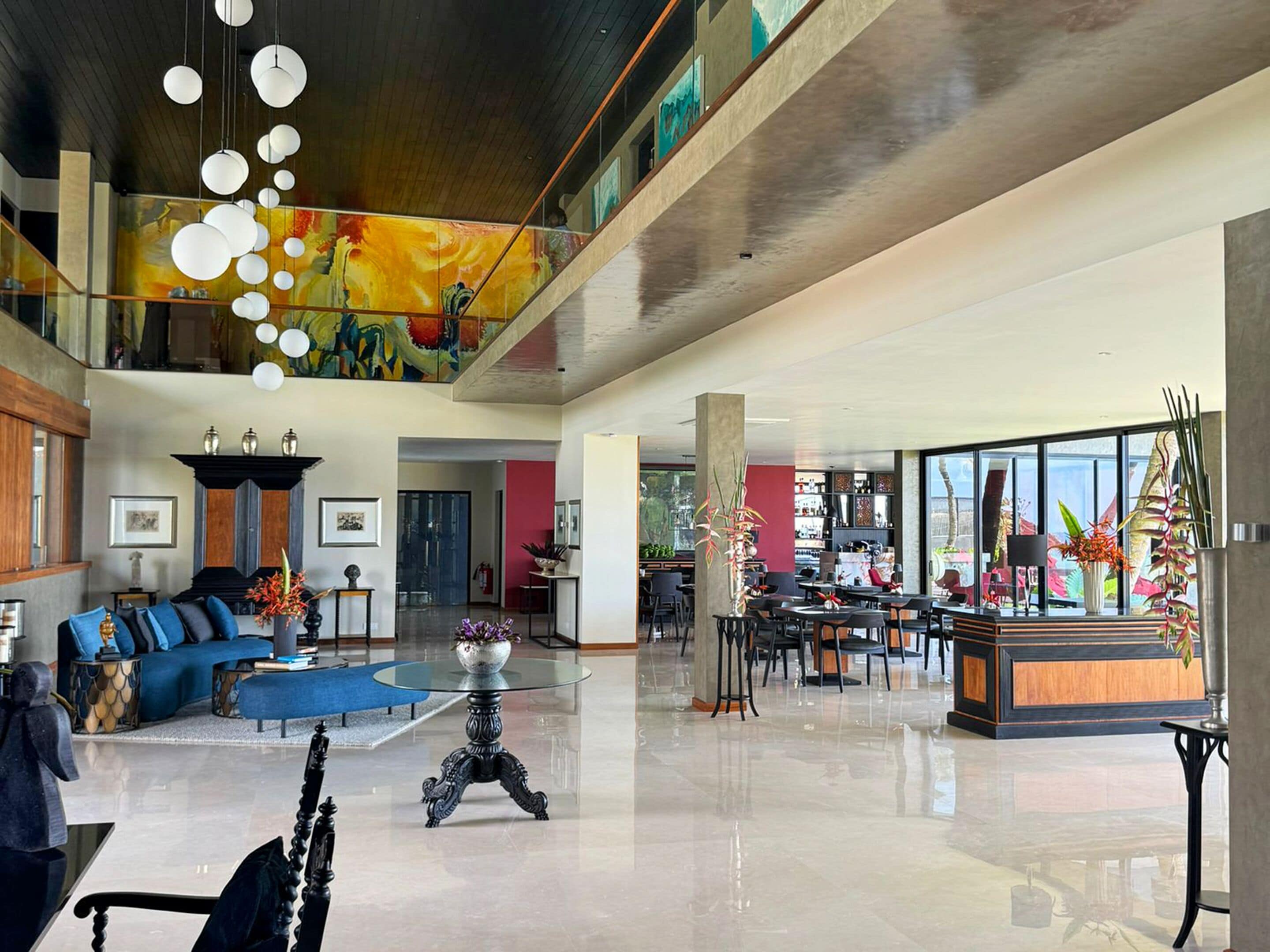 Un hall d’entrée spacieux avec un plafond haut, un espace salon central et un coin repas offrant une vue sur l’extérieur.