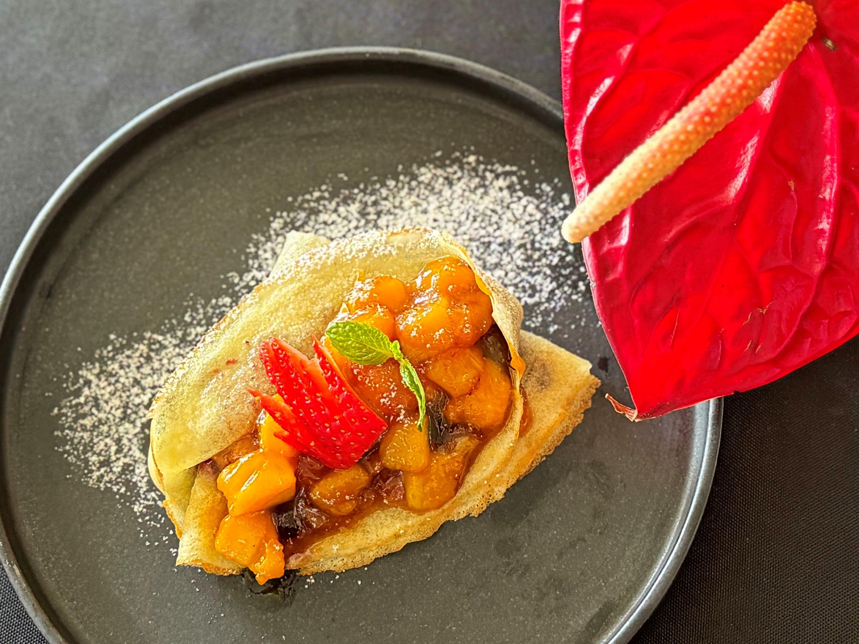 A dessert with fruit and a red napkin on a plate.