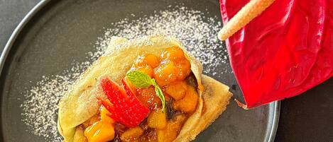 Postre con fruta y un mantel individual rojo sobre un plato.