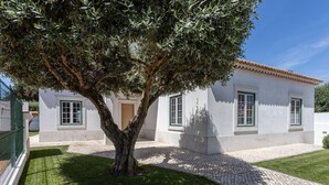 A white building with green window frames and a tiled roof. - Casa Das Azeitonas (Azeitão)
