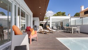 A rooftop pool area with lounge chairs, a table, and a glass-enclosed space. - Casa Branca - Magnificent villa with private pool (Aroeira)