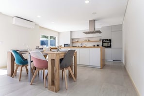 A modern kitchen with white cabinets, a wooden island, and a built-in oven.