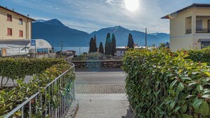 A pathway leading to a mountain view with buildings on either side. - Pianello Charming Lake View (Pianello del Lario)