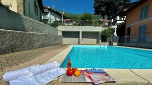 A poolside area with a towel, fruits, and a magazine. - Pianello Charming Lake View (Pianello del Lario)
