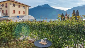 A table with a cup and a thermos in front of a building with a mountain in the background. - Pianello Charming Lake View (Pianello del Lario)