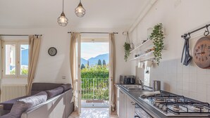 A kitchen with a gas stove, a sink, and a view of the outdoors. - Pianello Charming Lake View (Pianello del Lario)