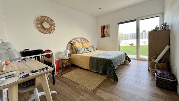 A bedroom with a bed, desk, chair, and a view of the outdoors. - Casa Marido - Villa with swimming pool (Pinhal do Cabedal)