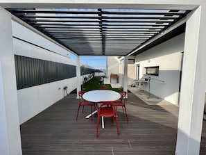 An outdoor patio with a table and chairs, a grill, and a view of the surrounding area. - Casa Marido - Villa with swimming pool (Pinhal do Cabedal)