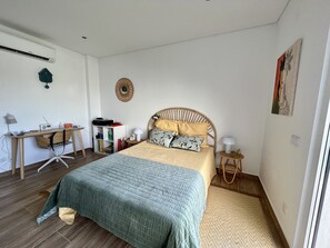 A bedroom with a bed, a desk, a chair, a bookshelf, and a wall clock. - Casa Marido - Villa with swimming pool (Pinhal do Cabedal)