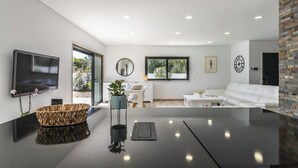 Un salon moderne avec un téléviseur à écran plat, un panier en osier et une plante en pot.