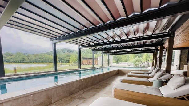 Area piscina con vista su un paesaggio naturale, che include uno specchio d'acqua e vegetazione.