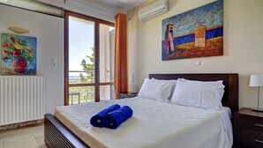 A hotel room with a bed, a painting, a radiator, and a window with curtains. - Bali private pool villa overlooking the lovely bay (Vlichada)