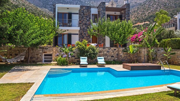 A modern two-story villa with a swimming pool, stone walls, and lush greenery. - Bali private pool villa overlooking the lovely bay (Vlichada)