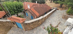 A stone-walled building with a tiled roof, a stone pathway, and a blue door. - Peloponnese Hideout-traditional stone house with amazing views and pet friendly  (Akrata)