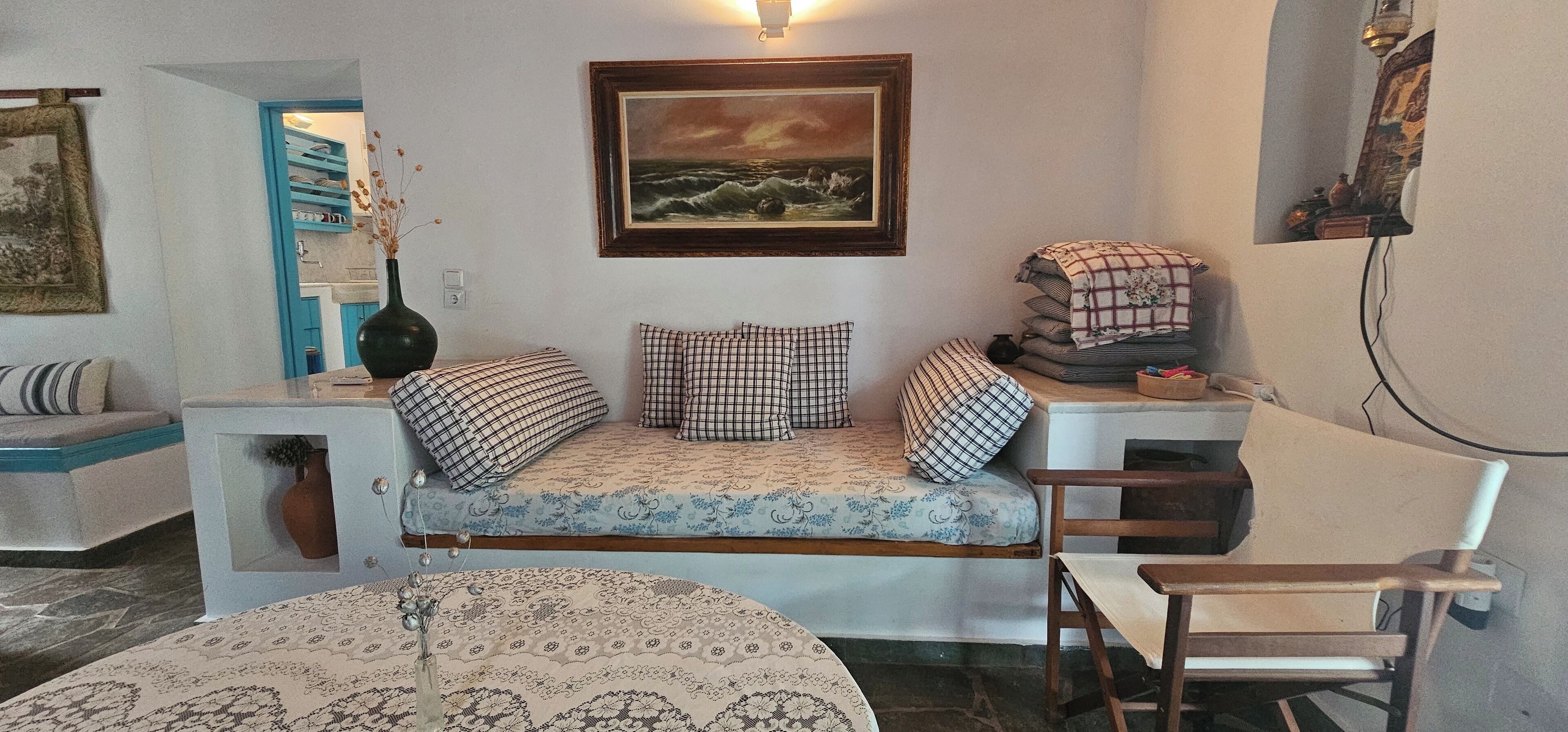 Un salón acogedor con un sofá, una mesita, una silla y un cuadro en la pared.