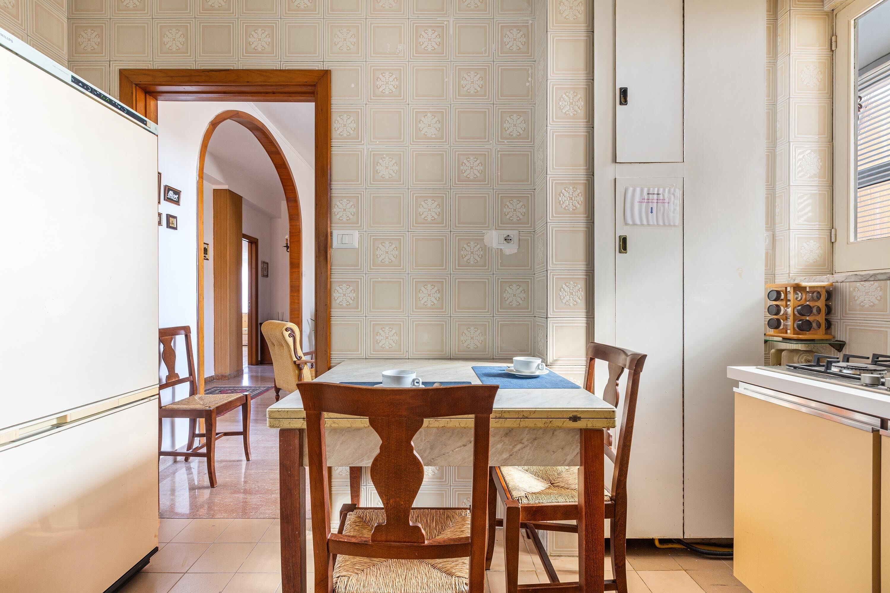 A kitchen with a dining table, chairs, and a stove.