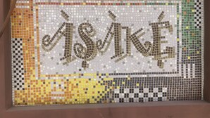 A mosaic wall with a geometric pattern and the word "ISAKI" prominently displayed. - FOSTER INN -ASAKE (Ibadan)