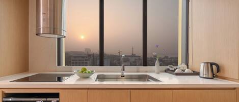 Una cocina moderna con un lavamanos de acero inoxidable, un lavavajillas Bosch y un horno Bosch. Hay una ventana con vista a un paisaje urbano.